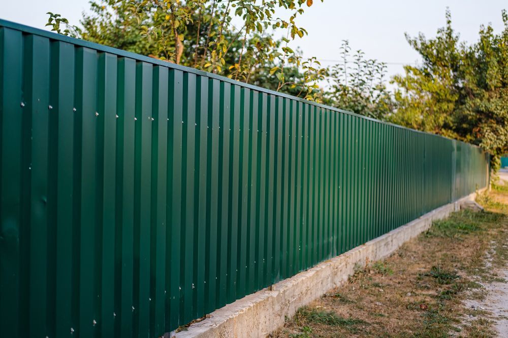 A Green Corrugated Metal Fence — Smiddy's Services In Budgewoi, NSW