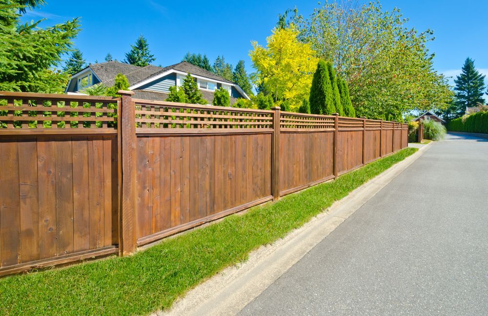 A Brown Wooden Fence Along a Street, Green Grass — Smiddy's Services In Morisset, NSW