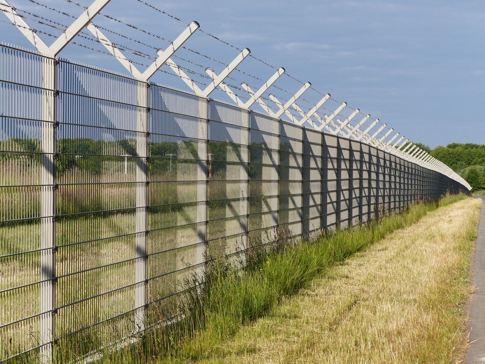 A Metal Security Fence With Barbed — Smiddy's Services In Morisset, NSW