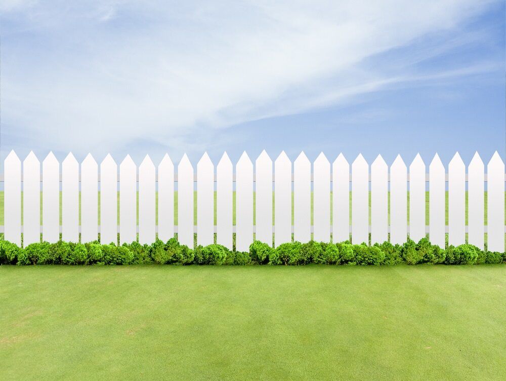 A White Picket Fence Surrounds A Lush Green Field — Smiddy's Services In Central Coast, NSW