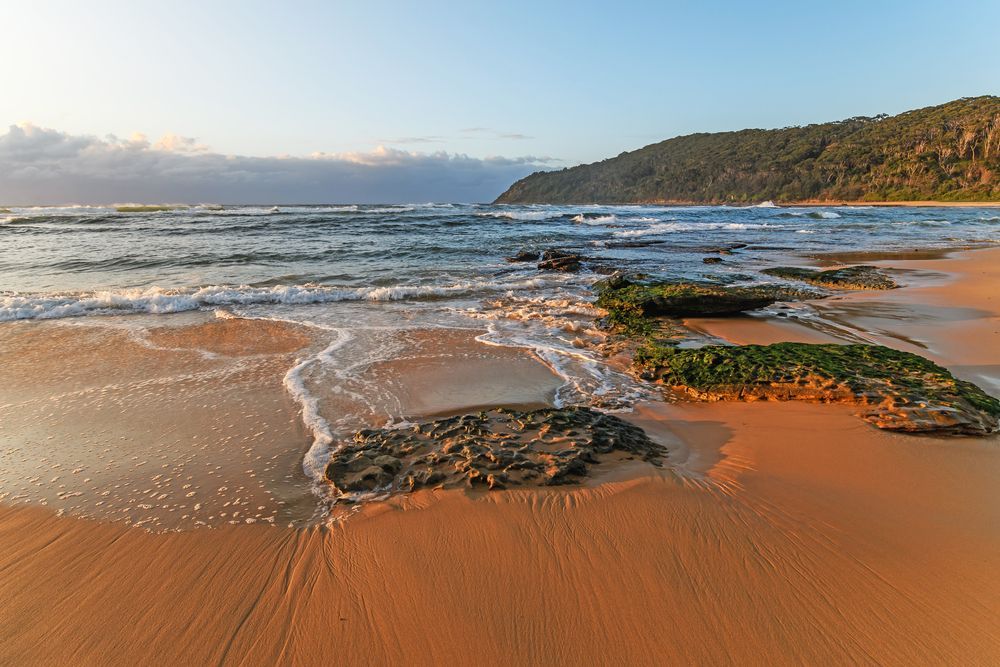 Beach at Sunset, With Waves, Sand, and a Dark Green, Forested Mountain — Smiddy's Services In Bateau Bay, NSW
