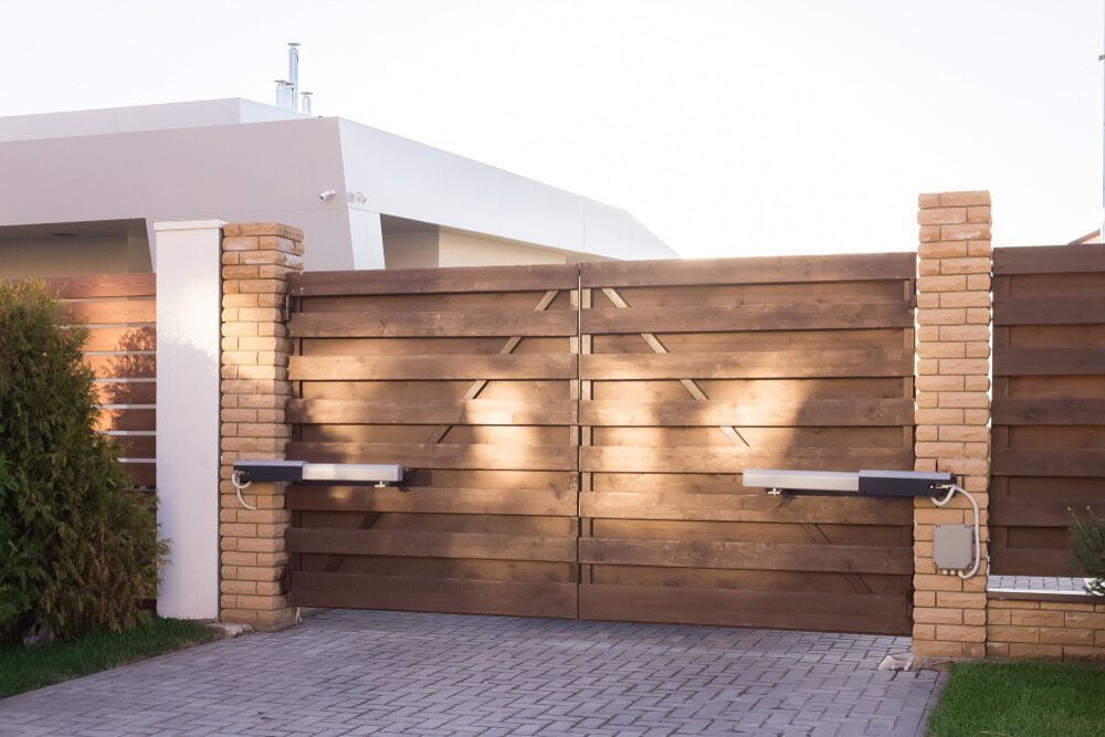 A Wooden Gate Is Open To A Driveway In Front Of A House — Smiddy's Services In Wyong, NSW