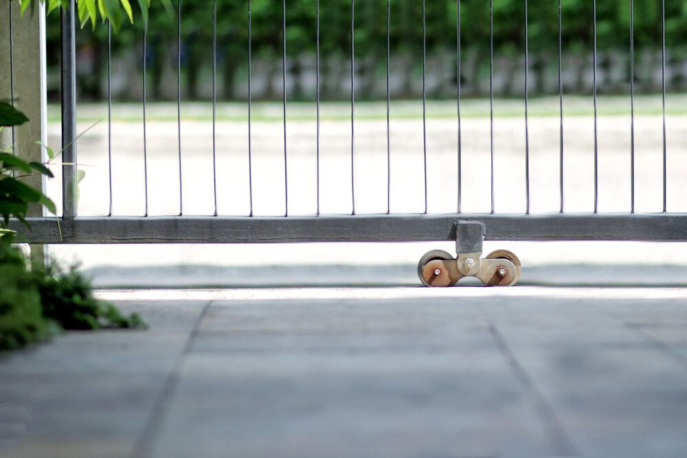 A Close Up Of A Sliding Gate With Wheels On It — Smiddy's Services In Gosford, NSW