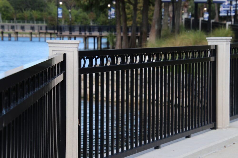 A Black And White Fence Surrounds A Body Of Water — Smiddy's Services In Gosford, NSW