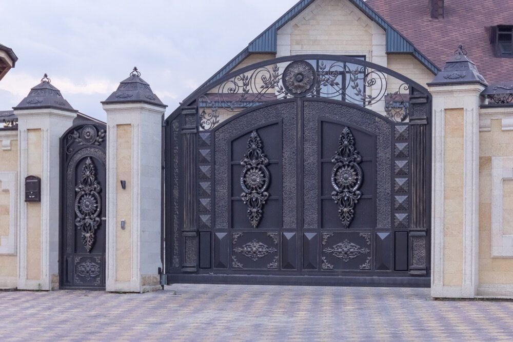 A Large Wrought Iron Gate Is In Front Of A House — Smiddy's Services In Lake Macquarie, NSW
