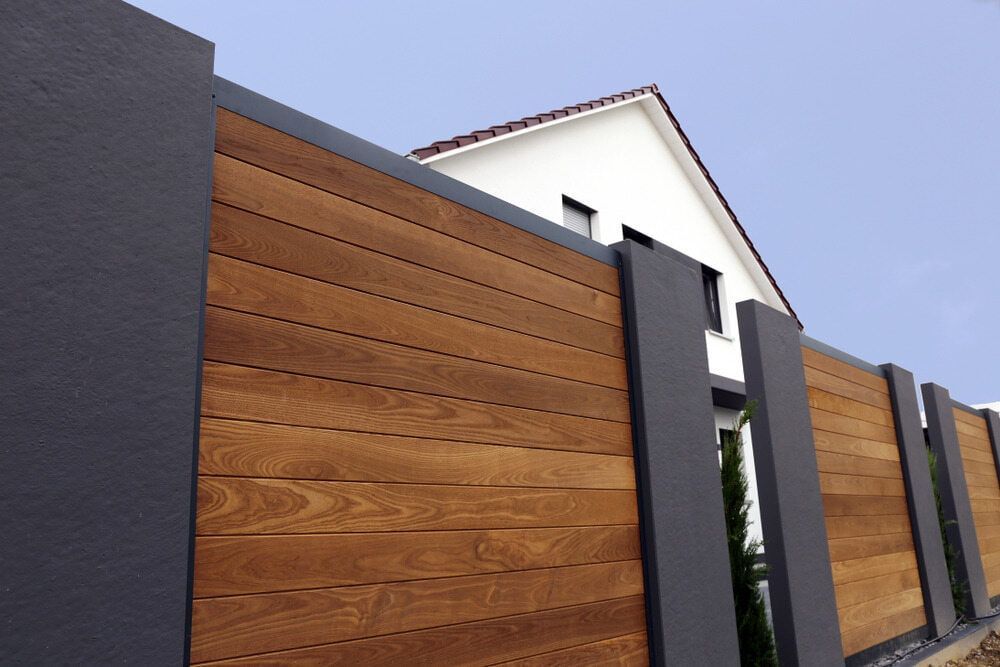 A Wooden Fence Is In Front Of A House — Smiddy's Services In Gosford, NSW