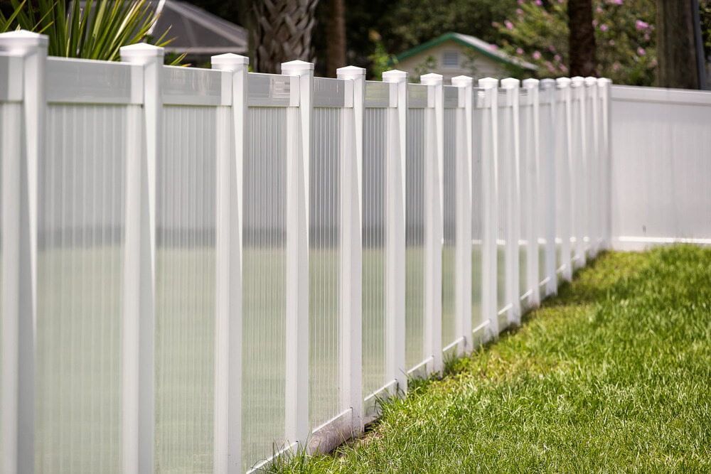 A White Fence Surrounds A Swimming Pool In A Backyard — Smiddy's Services In Lake Macquarie, NSW