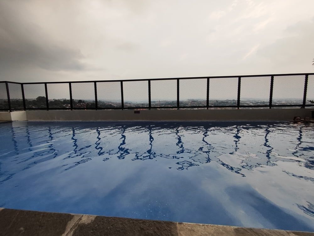 A Large Swimming Pool With A Fence Around It — Smiddy's Services In Tacoma, NSW