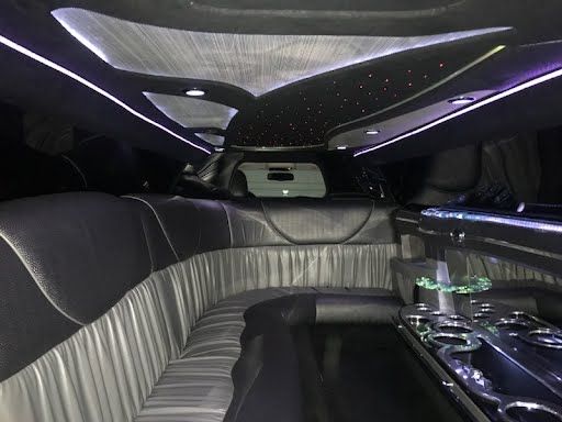 The inside of a limousine with a long couch and a table.