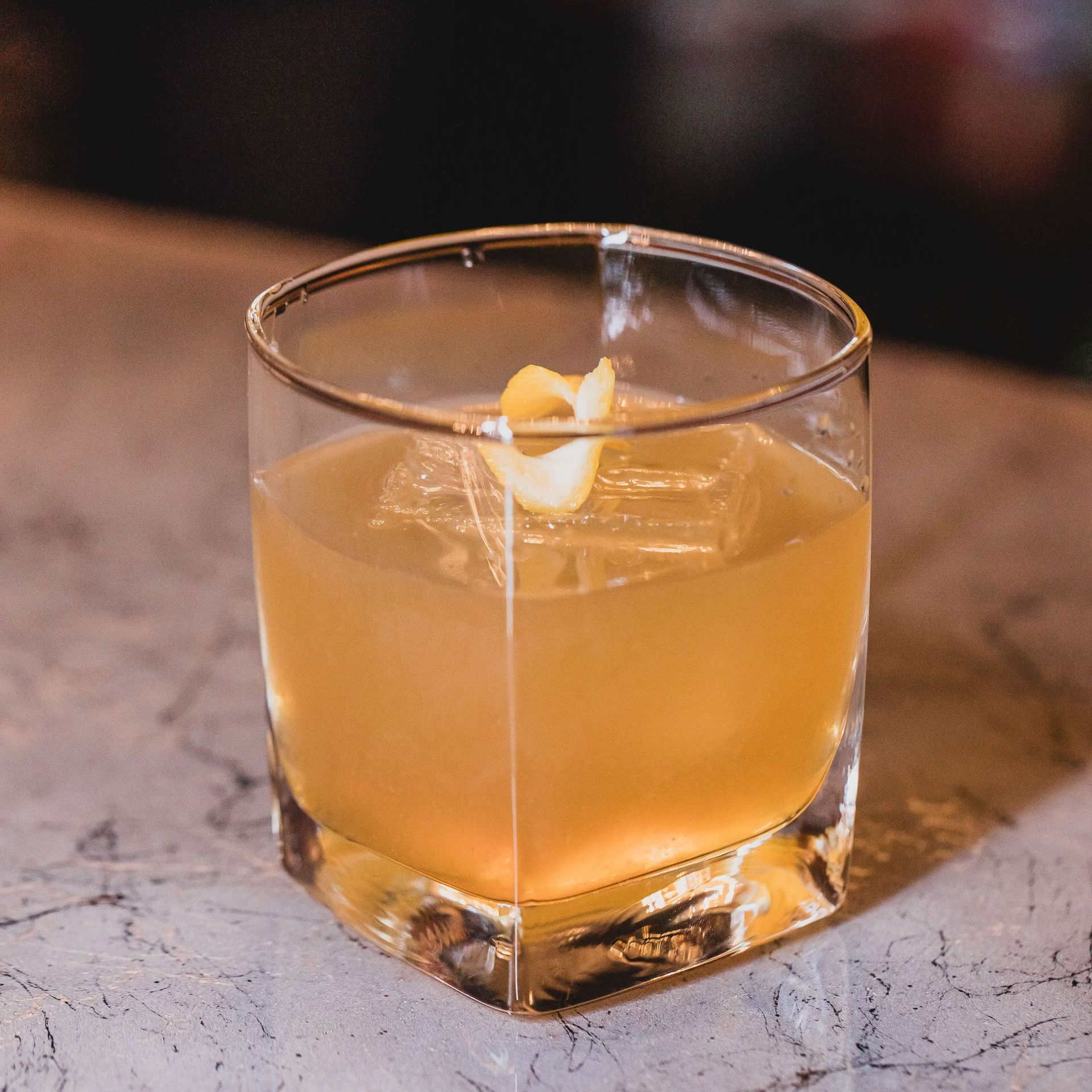 a close up of a gold rush cocktail in a glass on a table