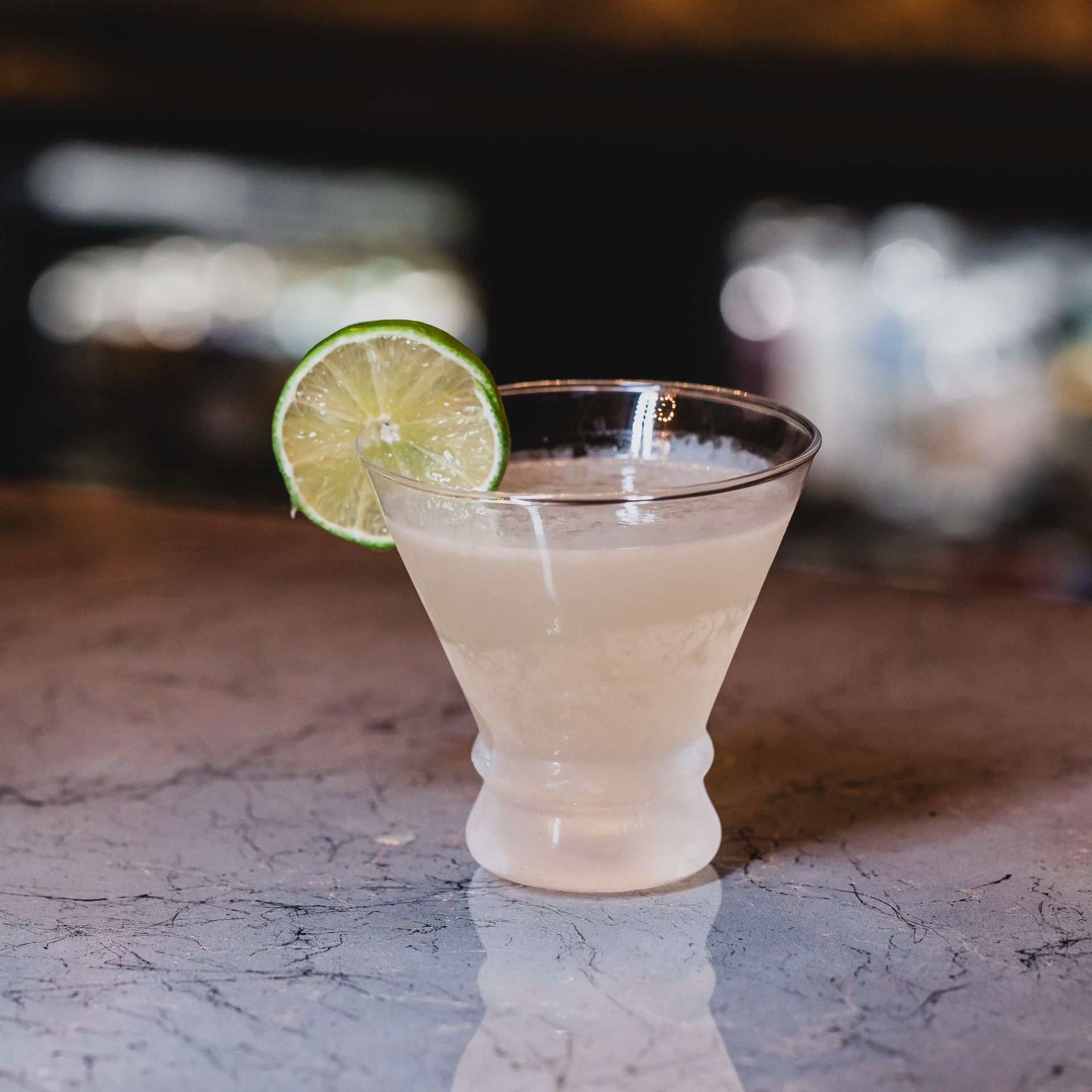 a glass of a margaria with a slice of lime on the edge of the glass