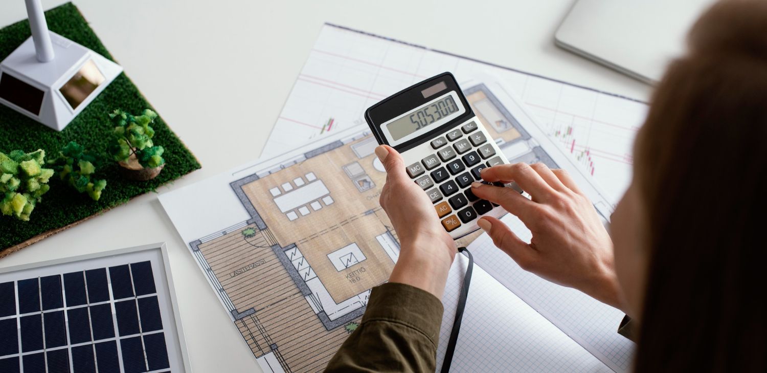 A person is using a calculator to calculate the cost of a house.