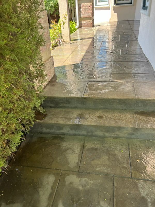 Concrete outdoor staircase with a dark red handrail.
