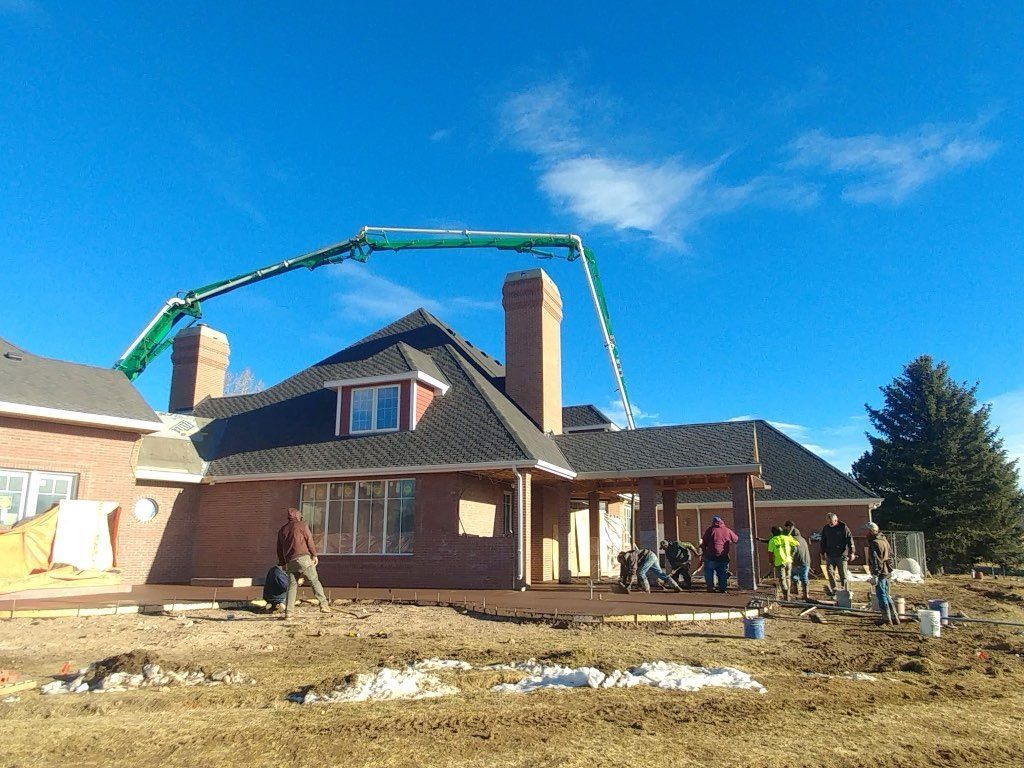 Modern house exterior with a driveway, garage, and landscaping under a blue sky.
