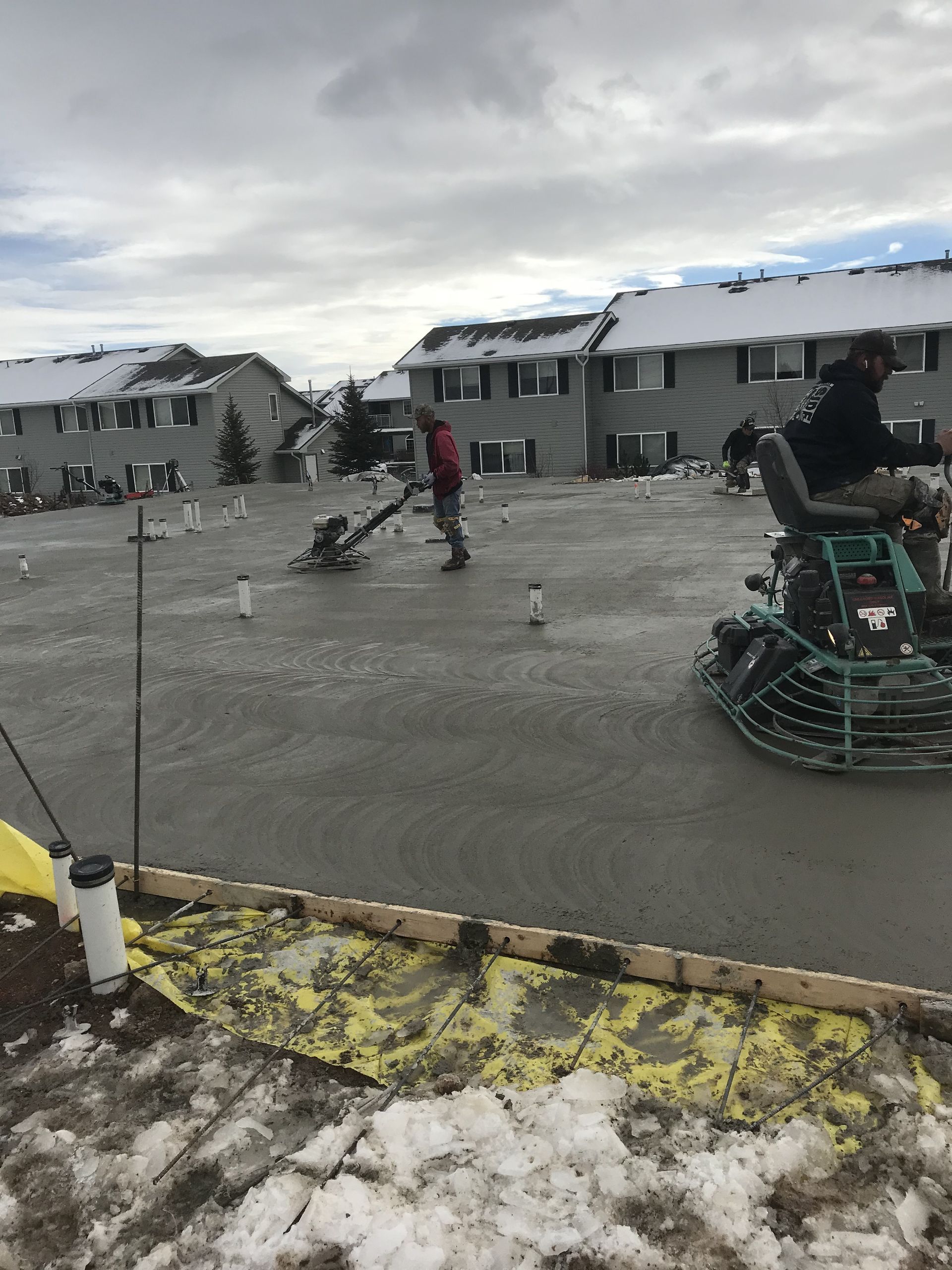 Construction site: crane over a building under construction, blue sky with clouds.