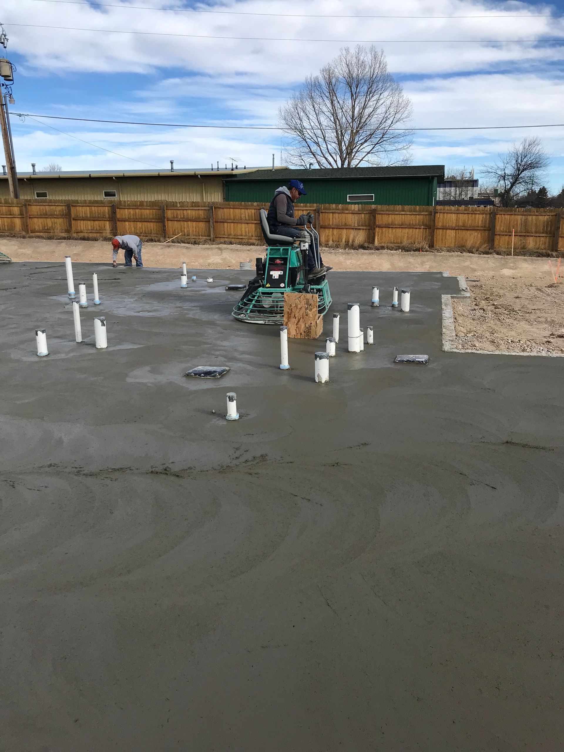 Large, empty industrial warehouse with brick floor, metal beams, and overhead crane system.