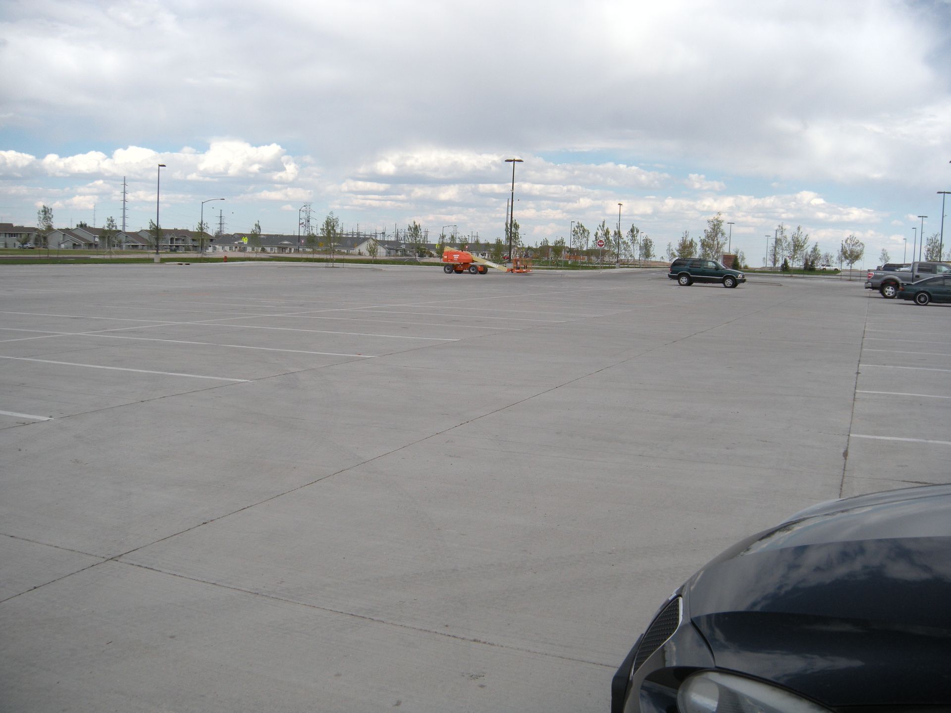 Construction worker inspecting a floor with a measuring tape, other worker in background, construction site.