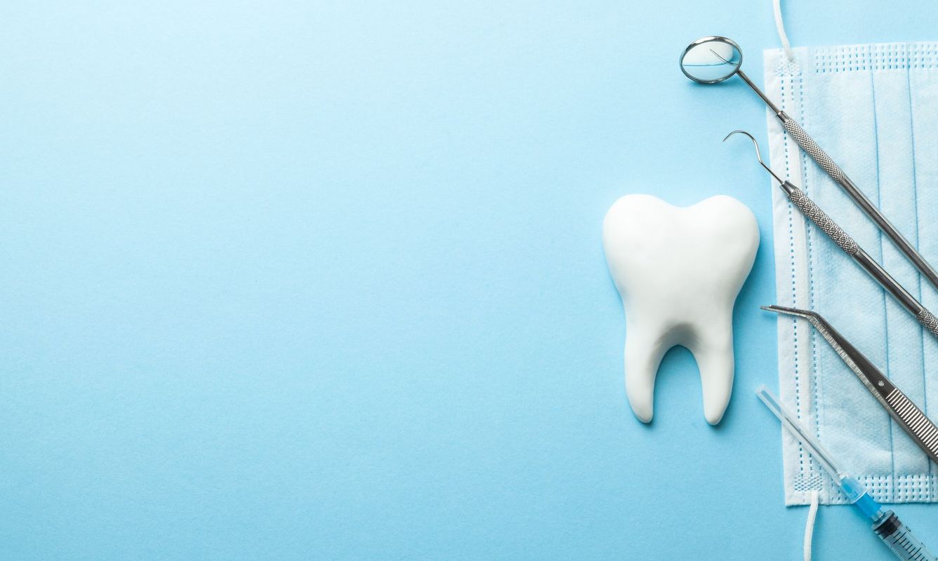 Tooth and dental instruments on blue background. Dental treatment