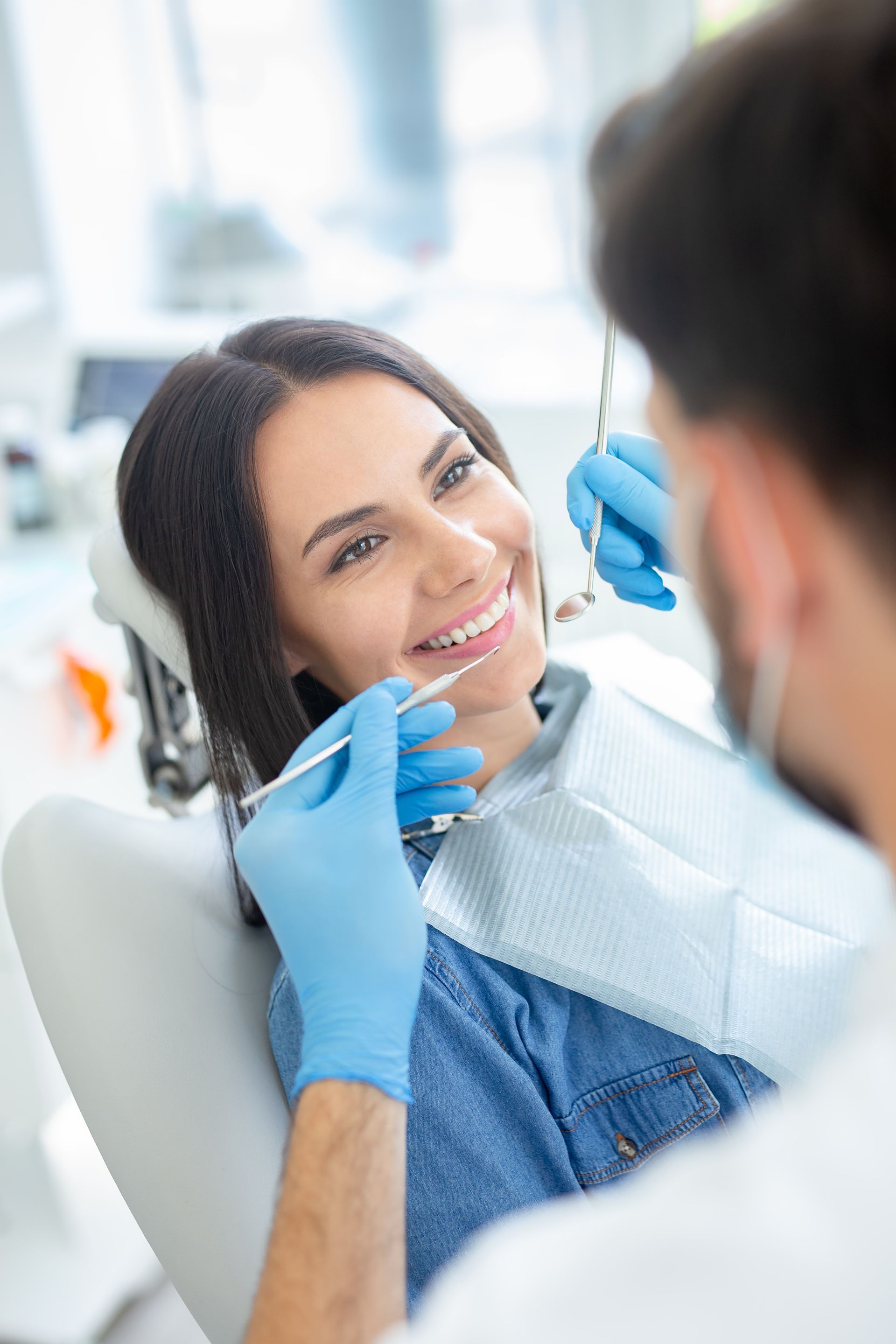 smiling female patient at dental procedure in modern dental clinic