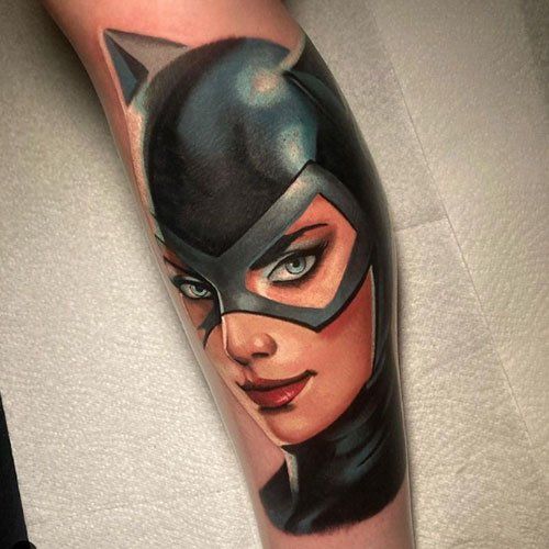 A tattoo of a woman in a catwoman costume on a leg.
