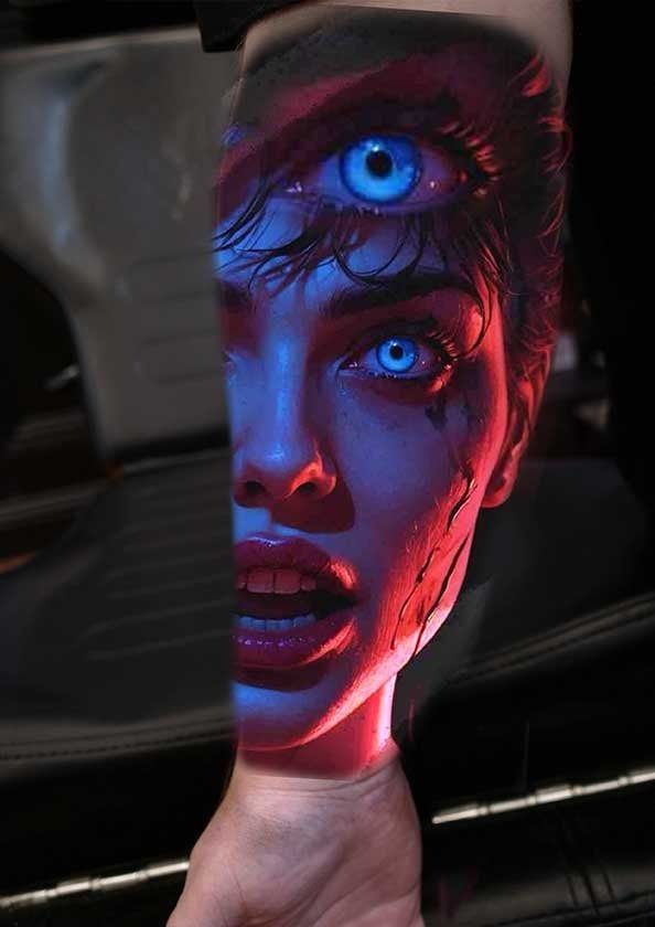 A person has a tattoo of a woman 's face on their arm.