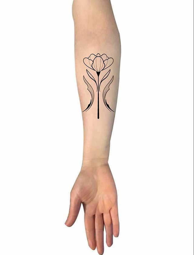 A person has a tattoo of a flower on their forearm.