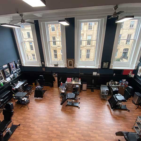 An aerial view of a tattoo parlor with lots of chairs and windows.