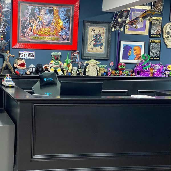 A black desk with a lot of toys on it in a room.