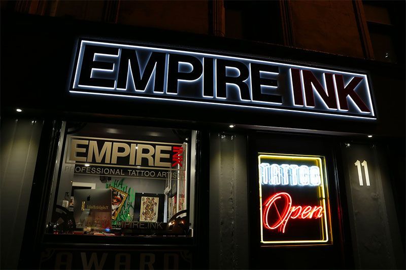 The empire ink tattoo shop is lit up at night