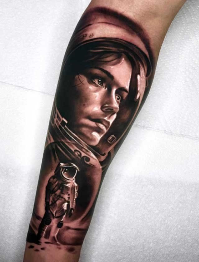 A tattoo of a woman in a space suit and an astronaut on a forearm.