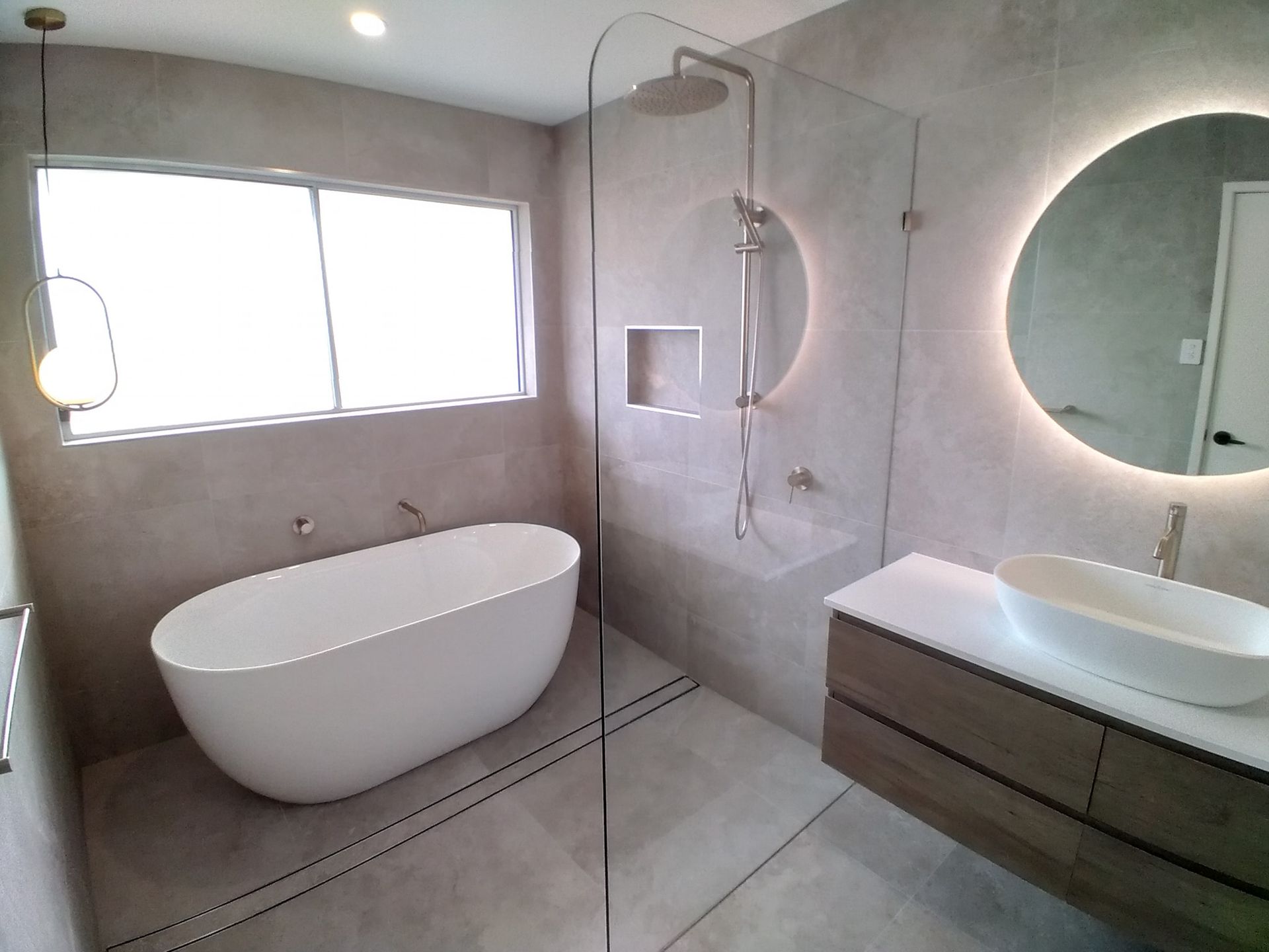 A bathroom with a bathtub , sink and shower.