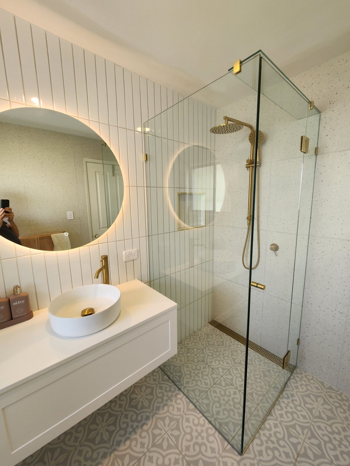 A bathroom with a walk in shower , sink and mirror.