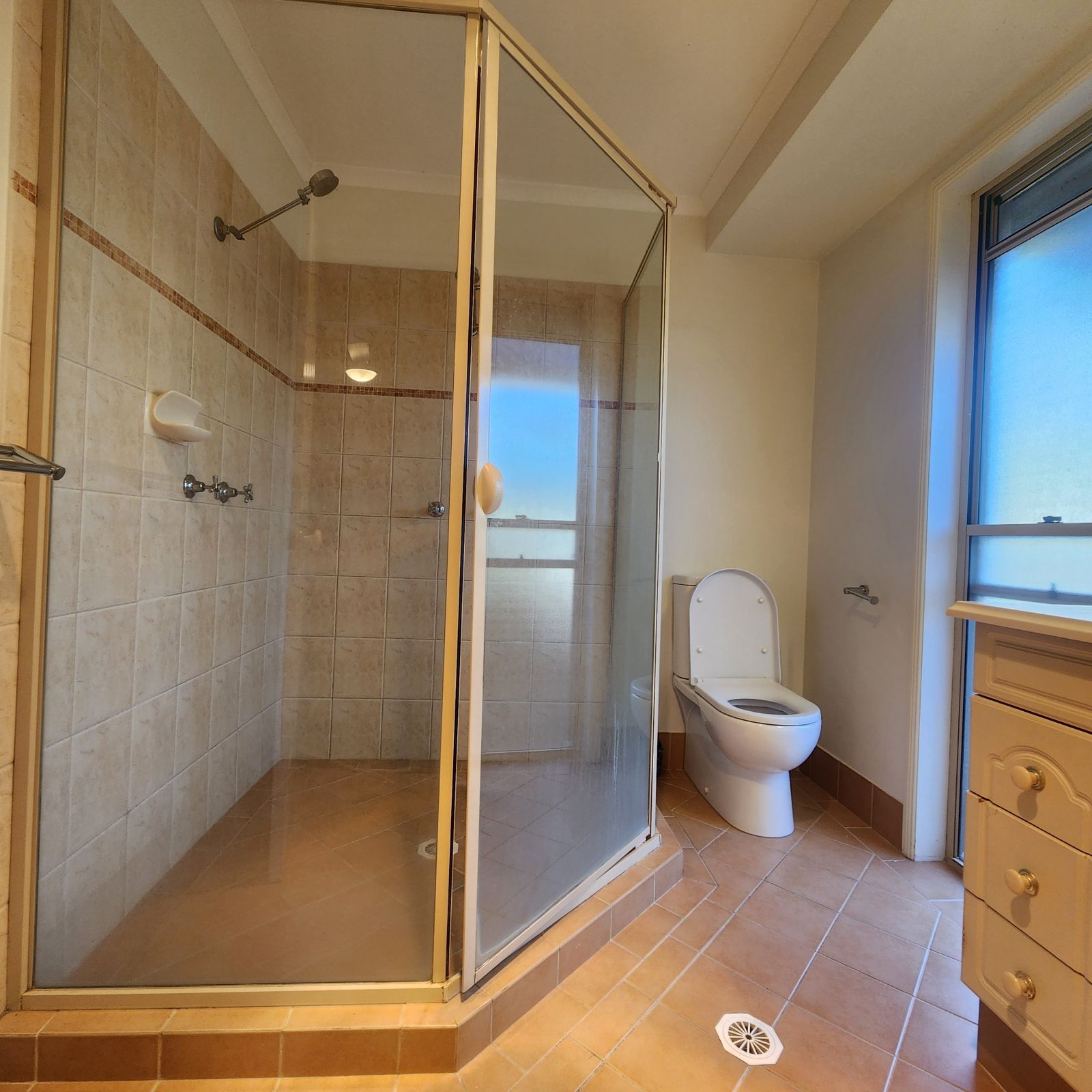 A bathroom with a toilet and a walk in shower