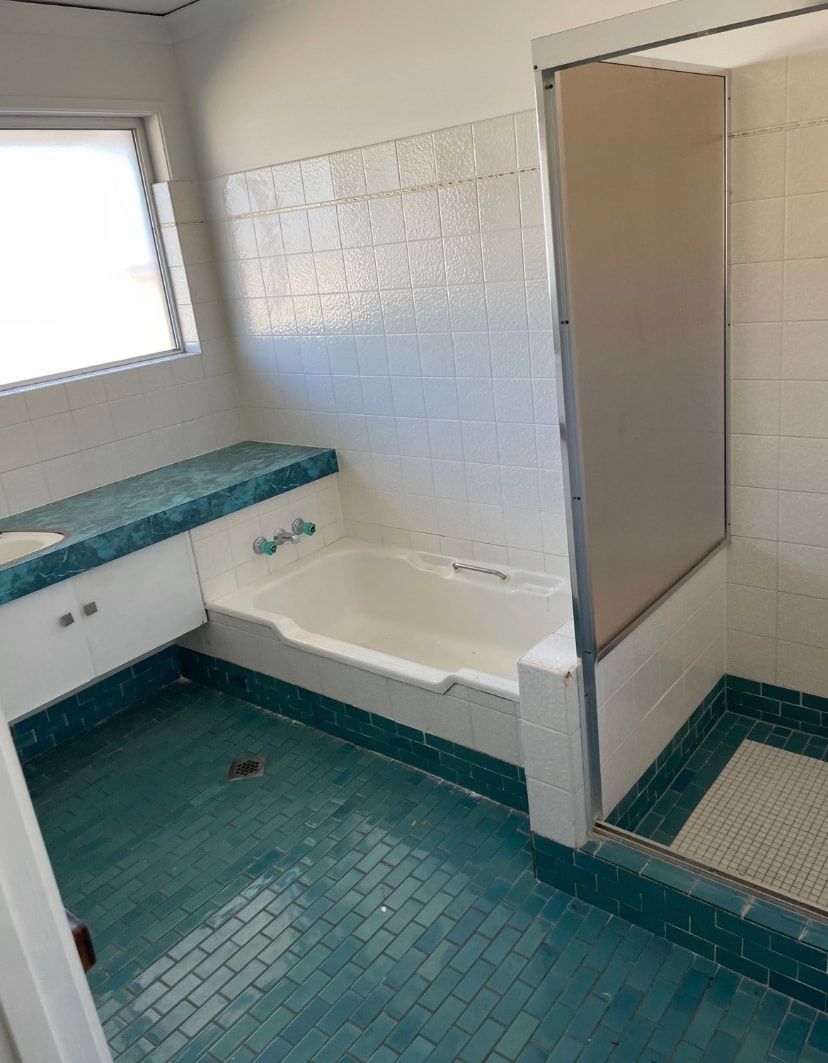 A bathroom with a bathtub , sink , and shower.