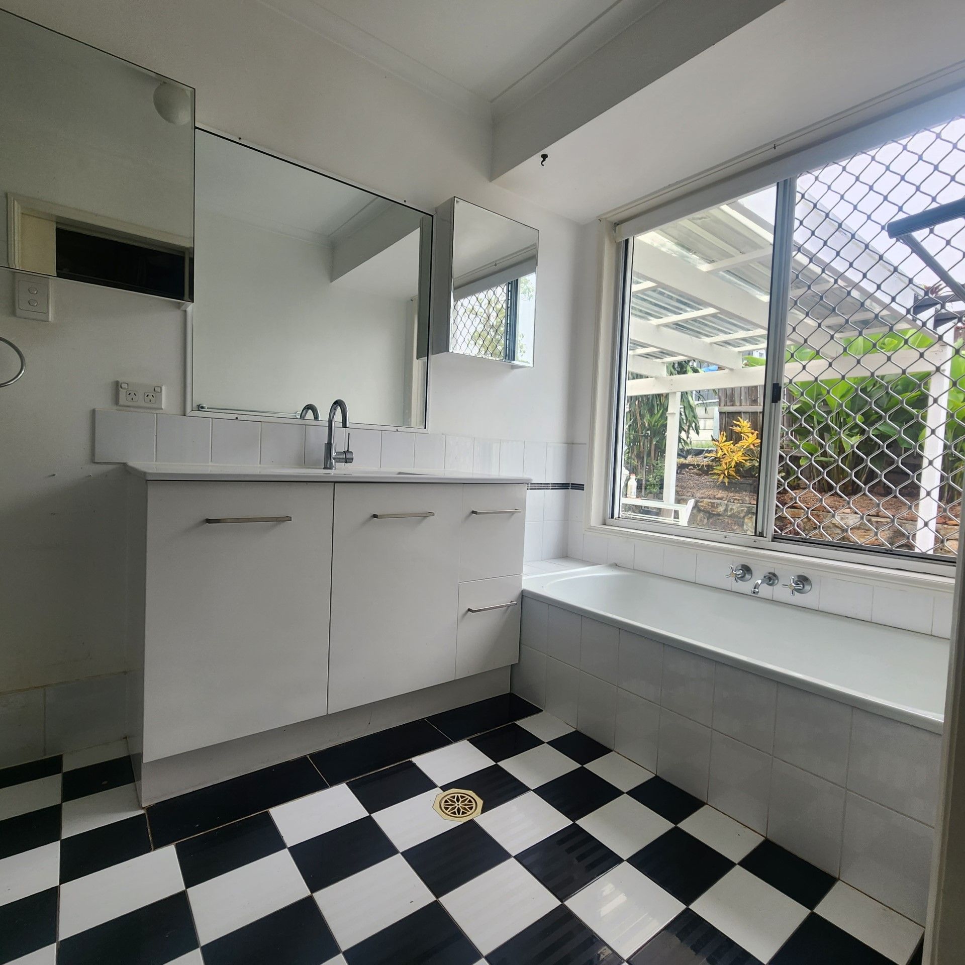 A bathroom with a black and white checkered floor