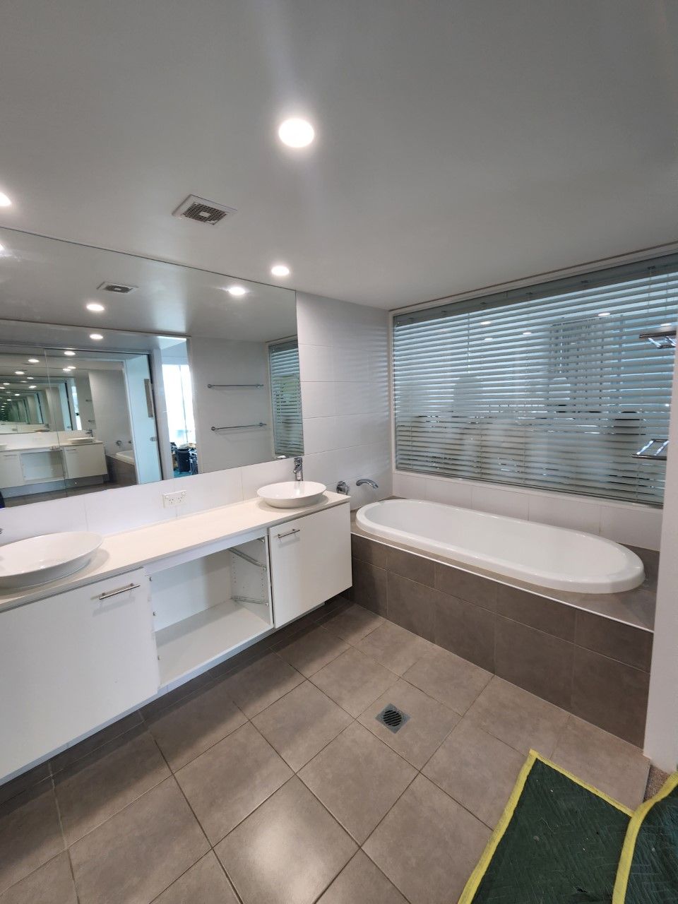 A bathroom with a tub , sink and mirror.