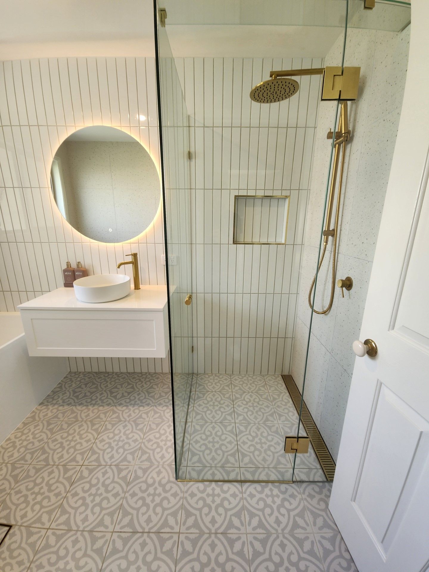 A bathroom with a walk in shower , sink and mirror.
