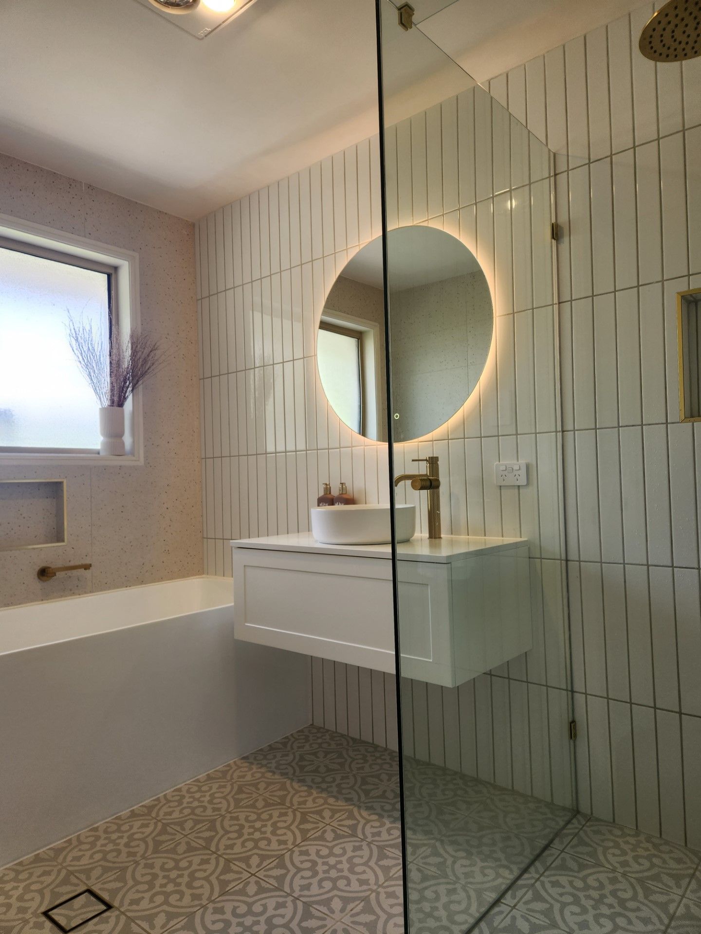 A bathroom with a sink , bathtub , shower and mirror.