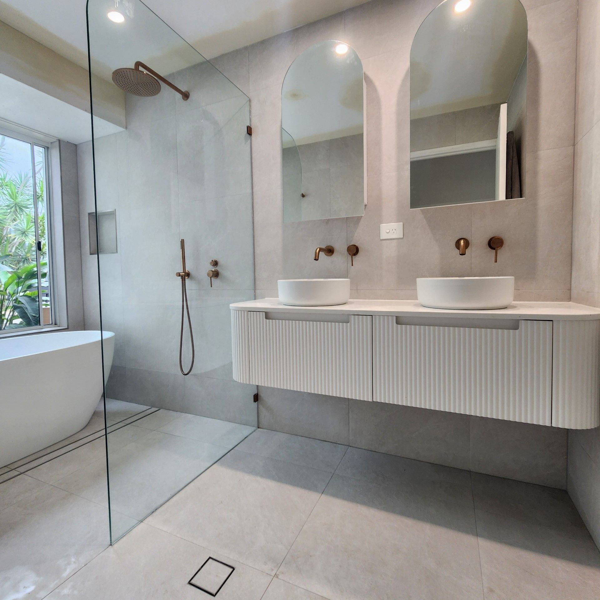 A bathroom with two sinks and a walk in shower