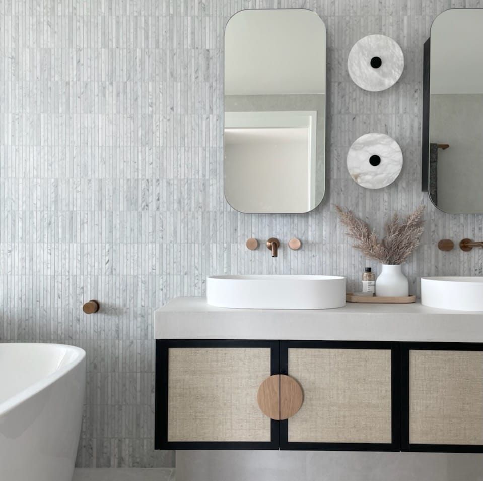 A bathroom with two sinks , two mirrors and a bathtub.