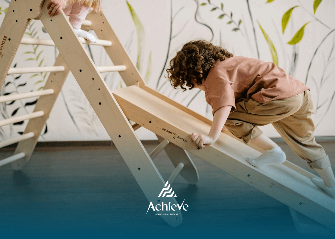 An autistic child climbing wooden play structure indoors during in-home ABA therapy in New Jersey.
