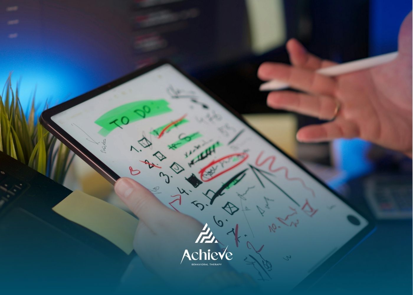 A person holds a tablet displaying a handwritten to-do list with checked-off tasks and red scribbles, in a workspace.