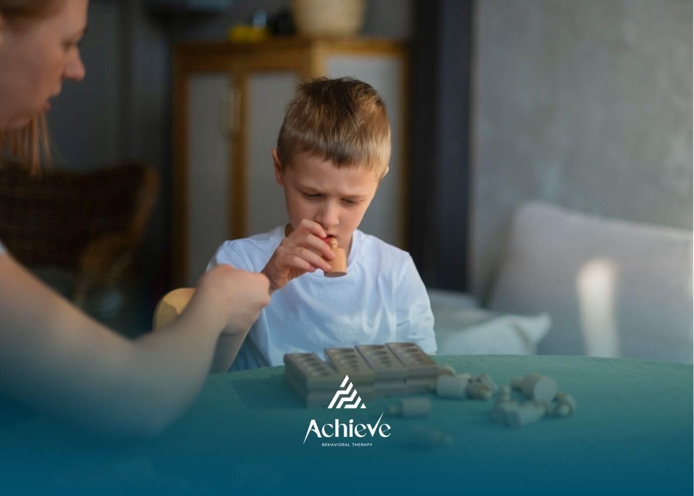 A young autistic boy carefully examining and manipulating wooden blocks with a woman guiding him.