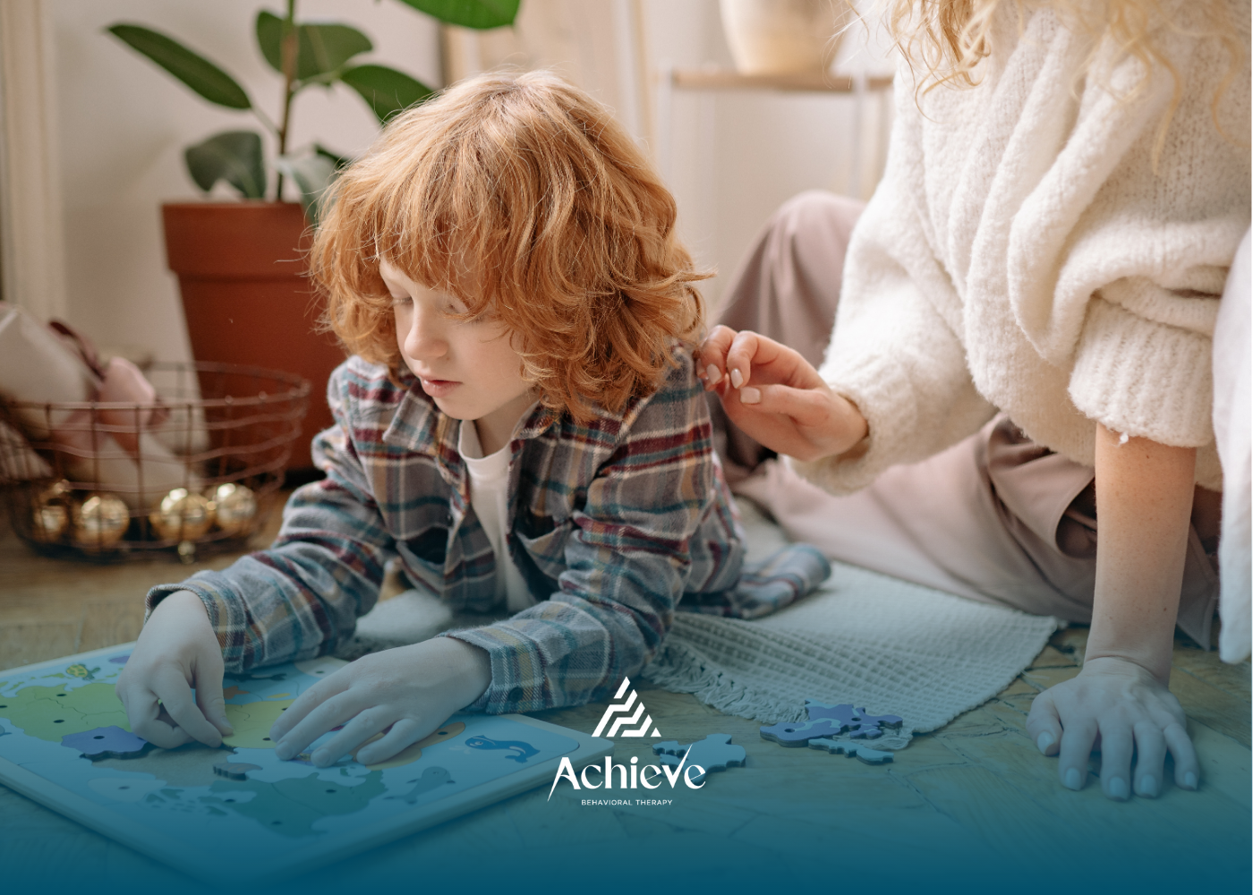 Boy with red hair doing a puzzle with a person's help. Indoors, natural light.