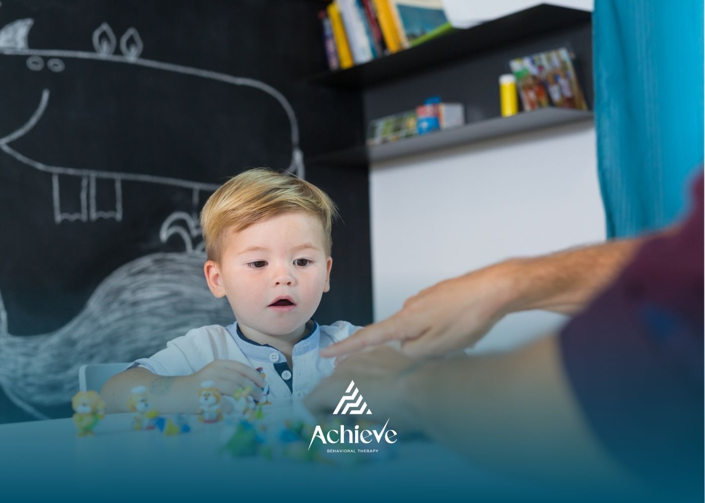 Young child playing with colorful toys at a table with an adult; hippo drawing on the wall.