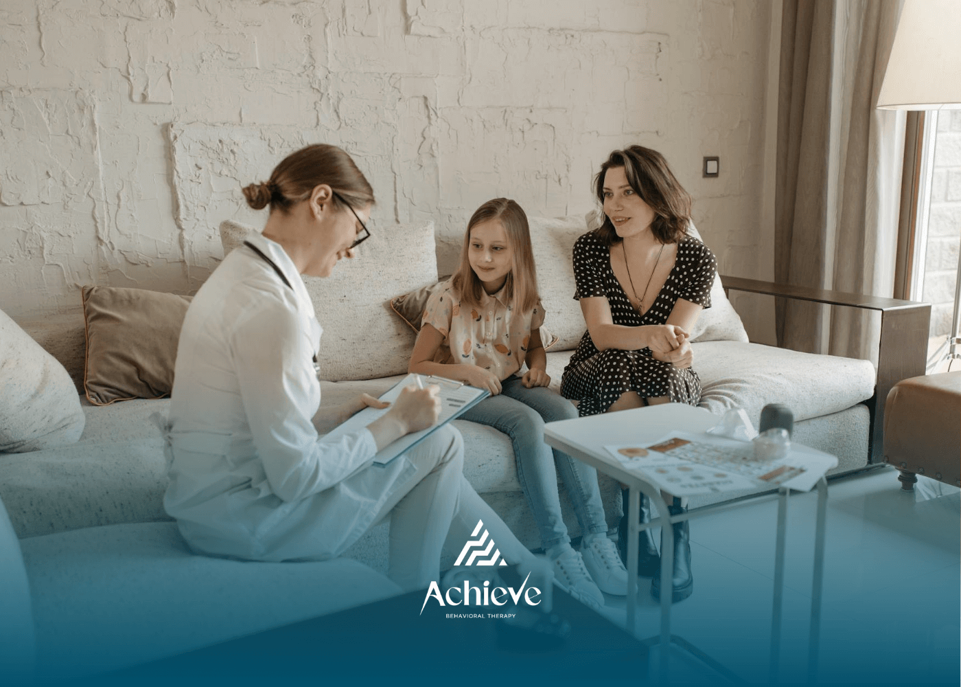ABA specialist chats with a mother and daughter during a home visit following their therapy session.