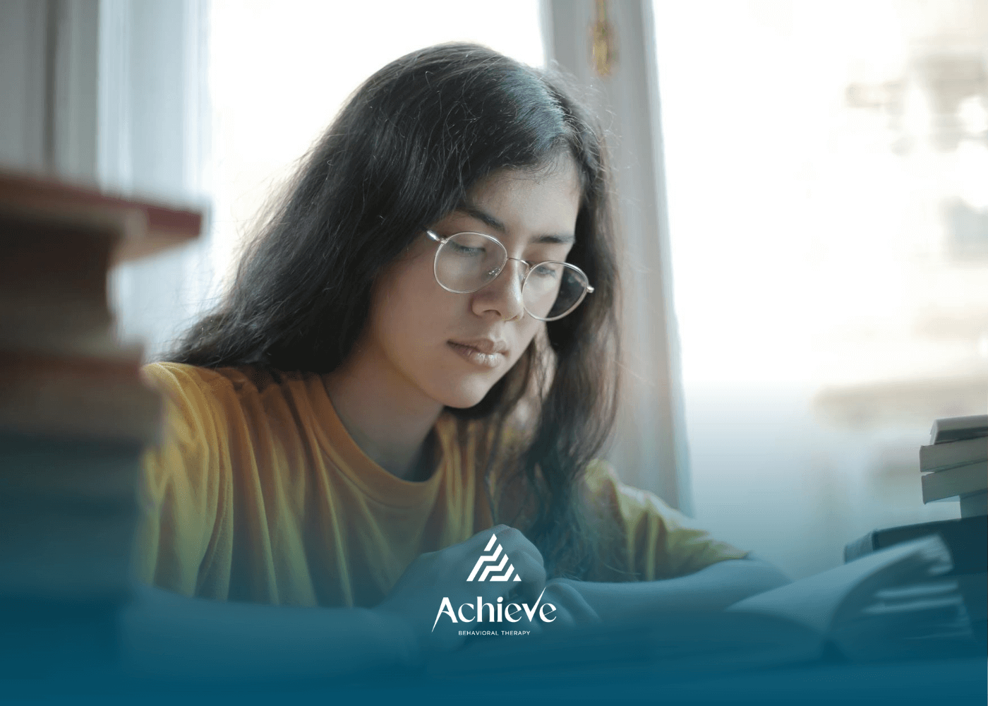Young BCBA student wearing a glasses & reading a book and reviewing in preparation for the exam.