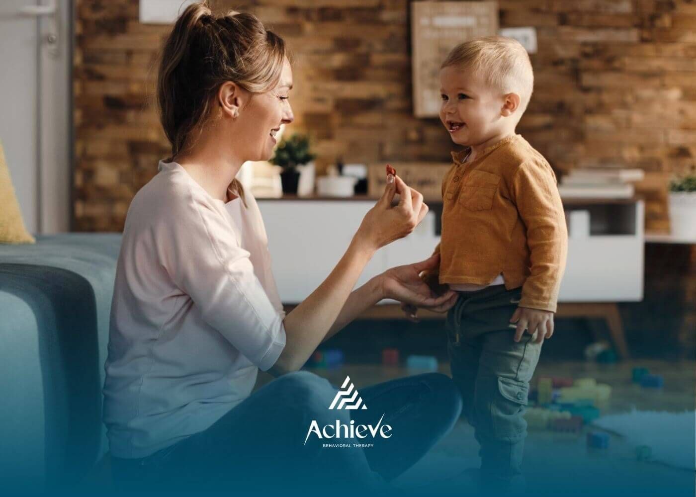 BCBA playing and interacting with a smiling toddler at home.