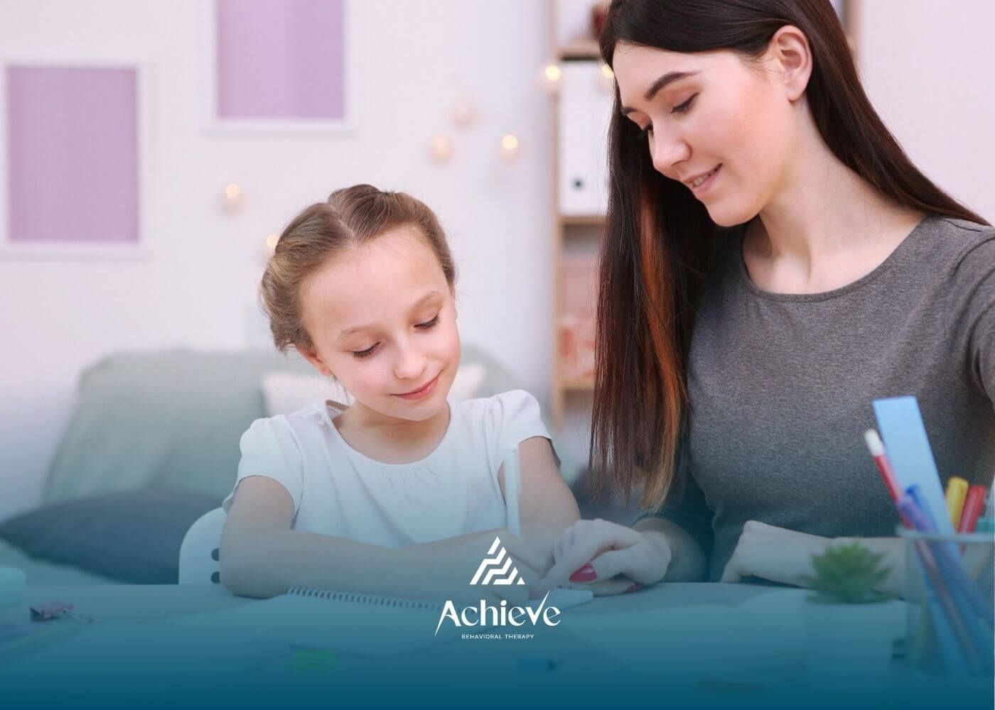 ABA therapist guiding girl during writing in-home ABA therapy activity.