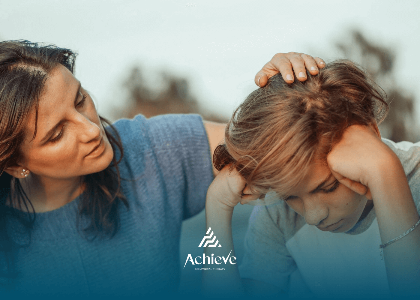 An ABA therapist comforting a sad autistic boy by gently placing a hand on their head after therapy